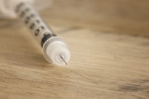 A hypodermic needle on a table.