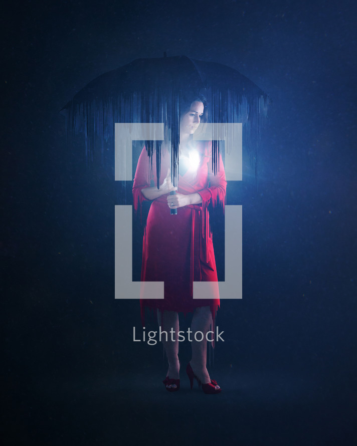 a woman standing under an umbrella in darkness 