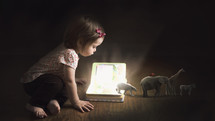 A toddler girl reading a Bible and learning about Noah's Ark 