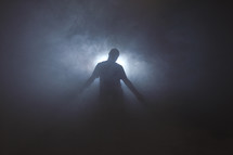 man standing in front of glowing light 