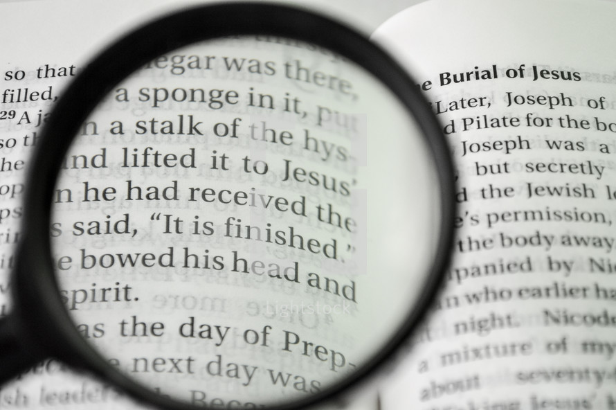 Magnifying glass over the pages of a Bible 