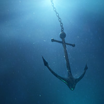An anchor sinks down through the water