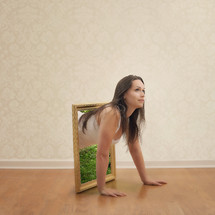 woman crawling out of a framed mirror 