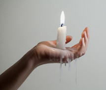 melting candle and wax in a woman's hand 