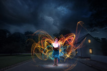 swirling colorful lights surrounding a woman at night 