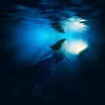woman reading a Bible under water 