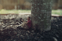 tiny man reading under a tree 