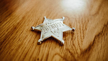 sheriff badge on a wood floor 