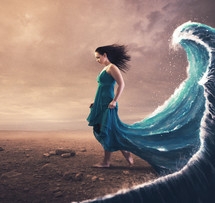 A woman with a blue dress and large wave behind her