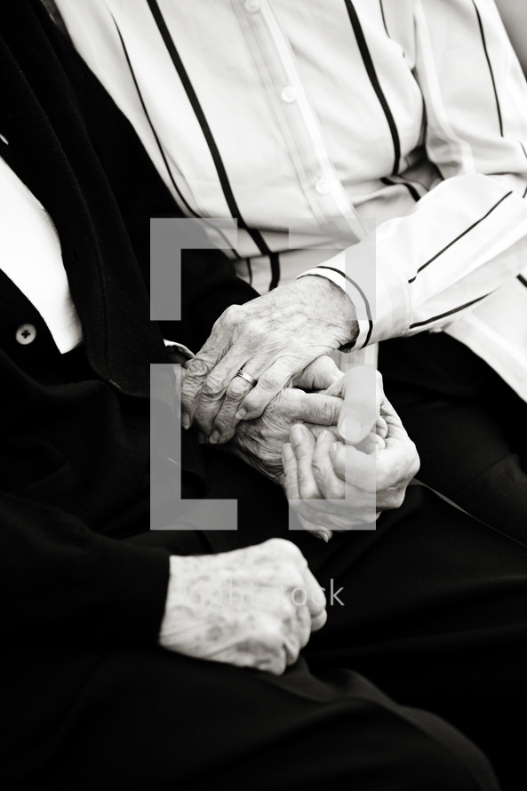 Grandparents holding hands and embracing.