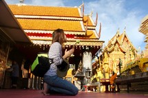 a woman kneeling down to pray in front of a shrine 