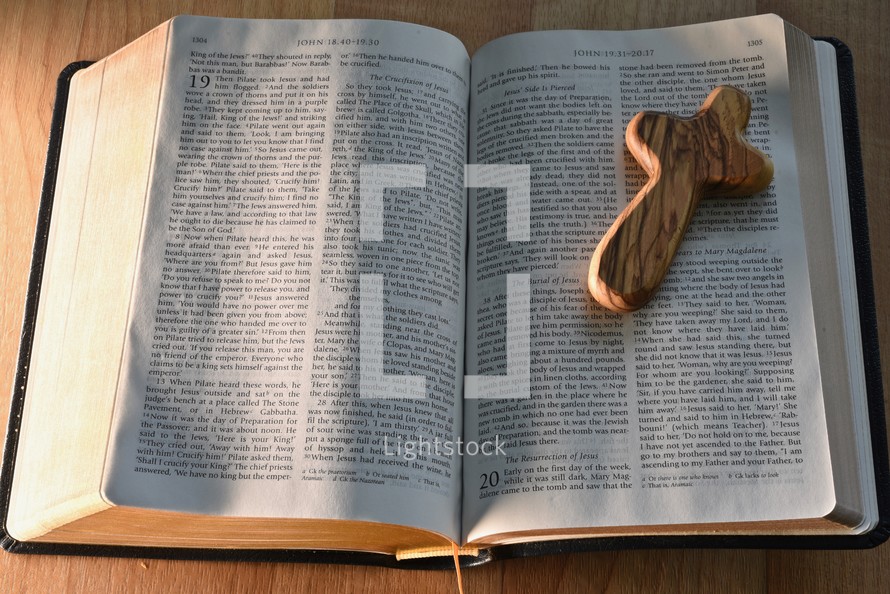 wooden prayer cross on the pages of a Bible 