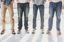 feet of men standing on a sidewalk 