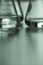 Clear liquid in scientific measuring flasks.