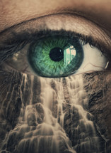 close up of an eye with a mountain waterfall super-imposed under the eye 