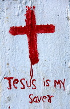 Roughly painted Christian Cross and the wording Jesus is my Savior in red paint on white background