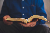 an elderly man reading a Bible 