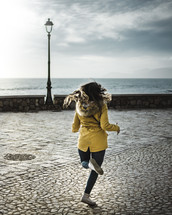 a woman running across stone pavers 
