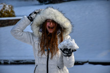 happy teen in a winter coating standing in snow 