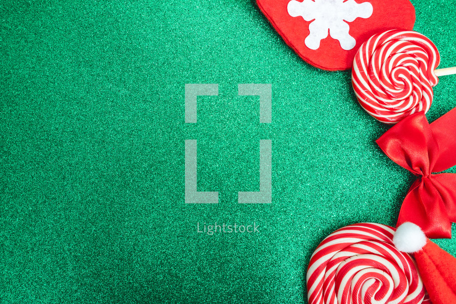 Flatlay of some red Christmas decoration, on a green background. Background for Christmas.