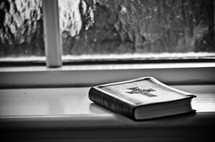 bible resting in a window sill 