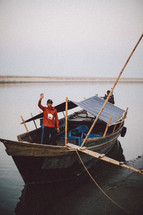 A man waving on a fishing boat 