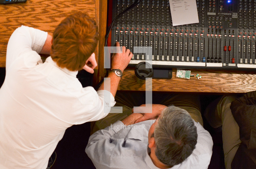two men working a soundboard