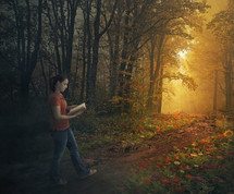 a girl walking along a forest trail lined by flowers reading a Bible 