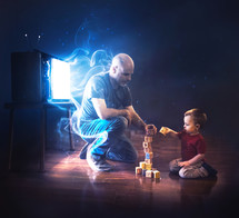 A father stands in front of the TV so he can play with his son.