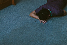 a man in tears lying on a church floor 