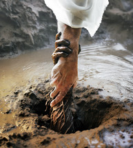 Jesus' hand reaching down and pulling someone out of the mud.