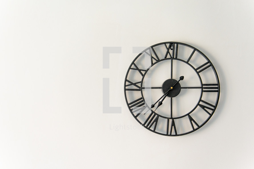 Vintage clock with Roman numeral. wall clock-face dialrustical on white wall in the apartment with copy space