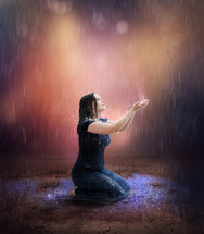 a woman kneeling in rain 