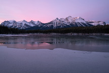 snow capped mountains and icy lake at sunset 
