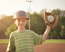 a child with a ball in his glove