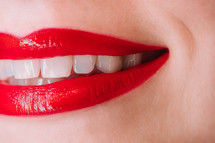 Woman with red liquid lipstick or gloss. Shiny smile. 