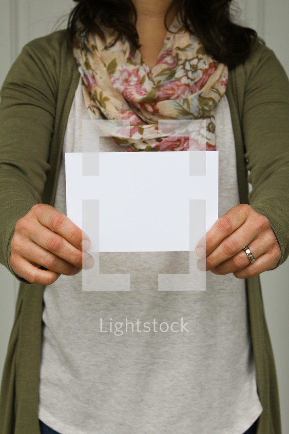a woman holding up a blank envelope