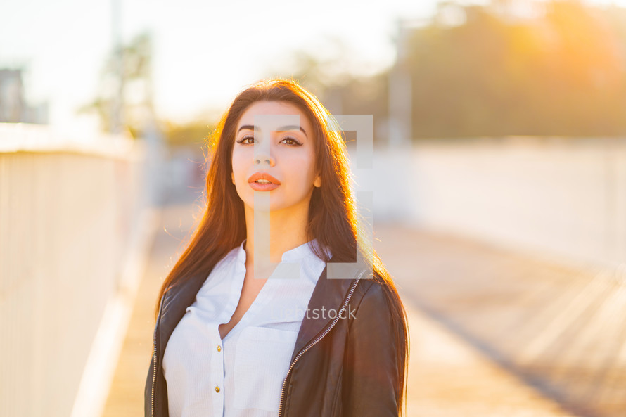 Portrait of young happy business woman in the city. Beautiful caucasian student girl in white blouse standing in the autumn street