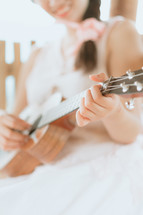 a woman playing a ukulele 