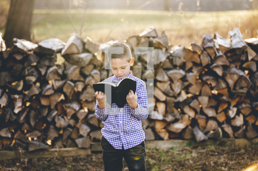 a little boy holding a Bible 