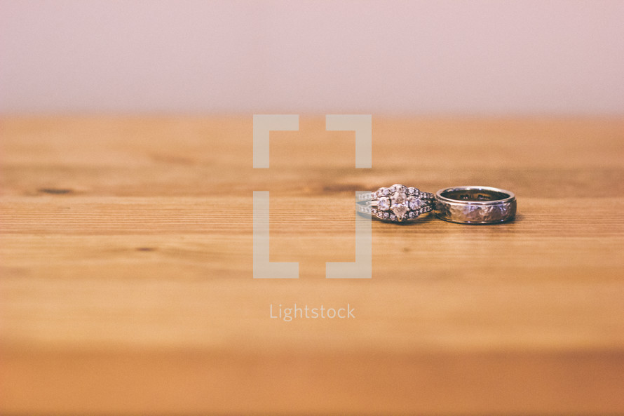 Wedding rings on a wooden table.