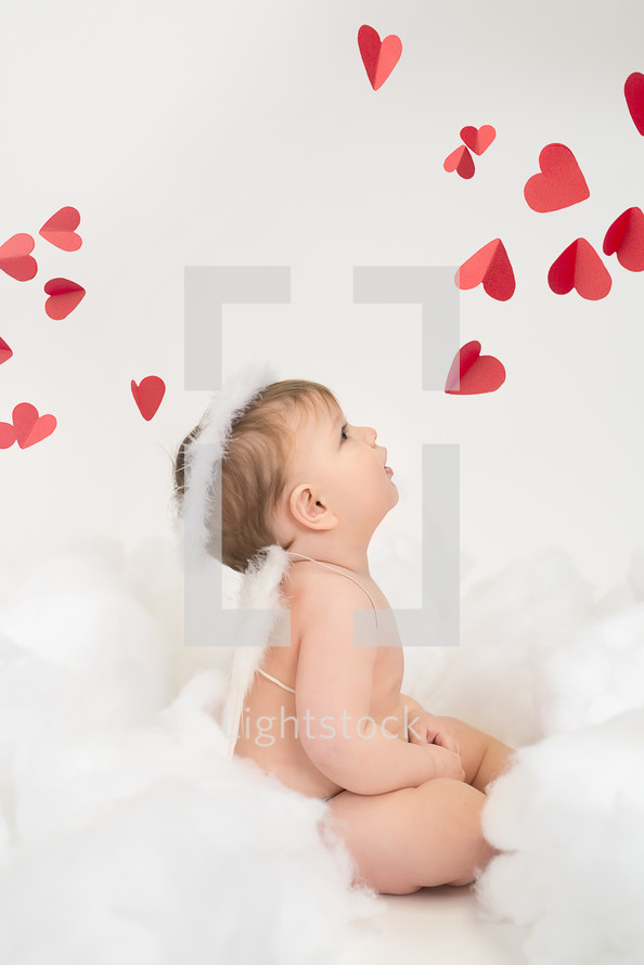 infant in angel wings and red hearts 