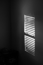 sunlight through cracks in blinds on a window 