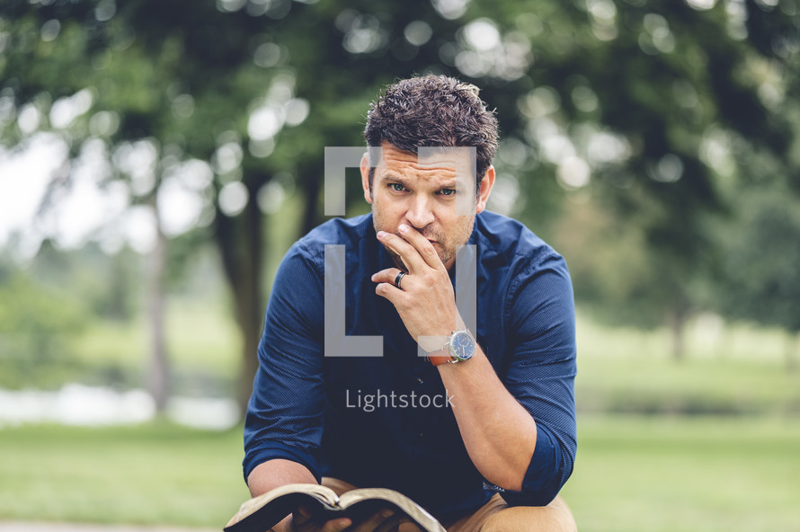 a man holding a Bible looking at the camera 