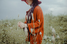 a woman in an orange sweater and hat 