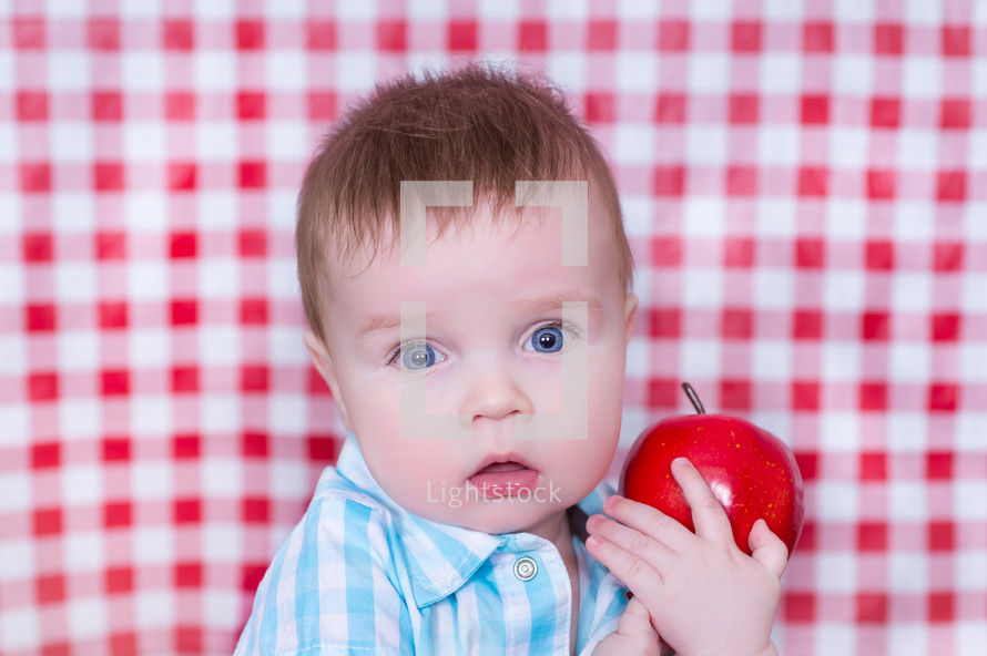 toddler boy holding an apple 