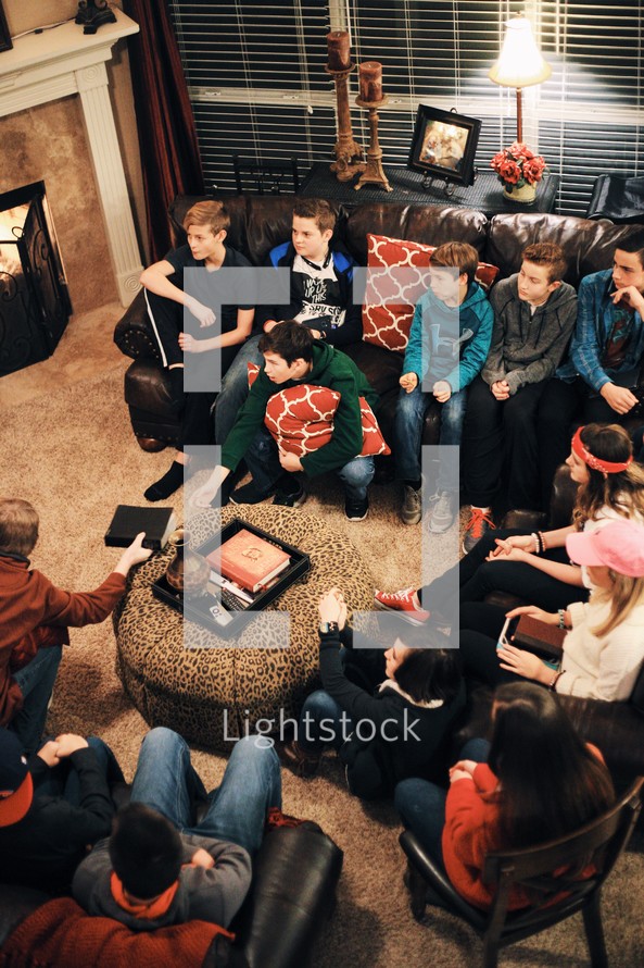 youth at a Bible study sitting on couches in a living room 