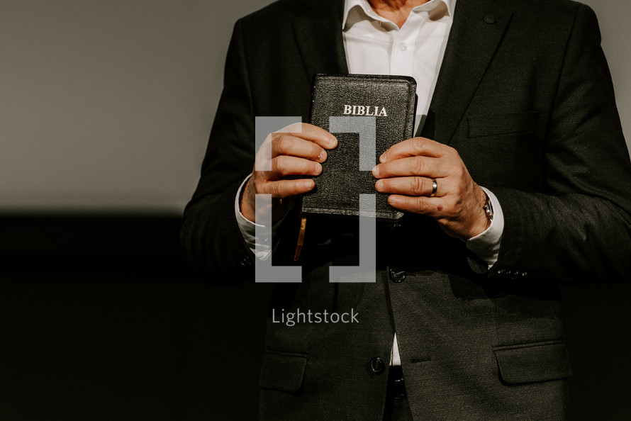 Pastor holding up a Spanish Bible during a sermon.