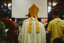 priest walking down the aisle at a worship service 