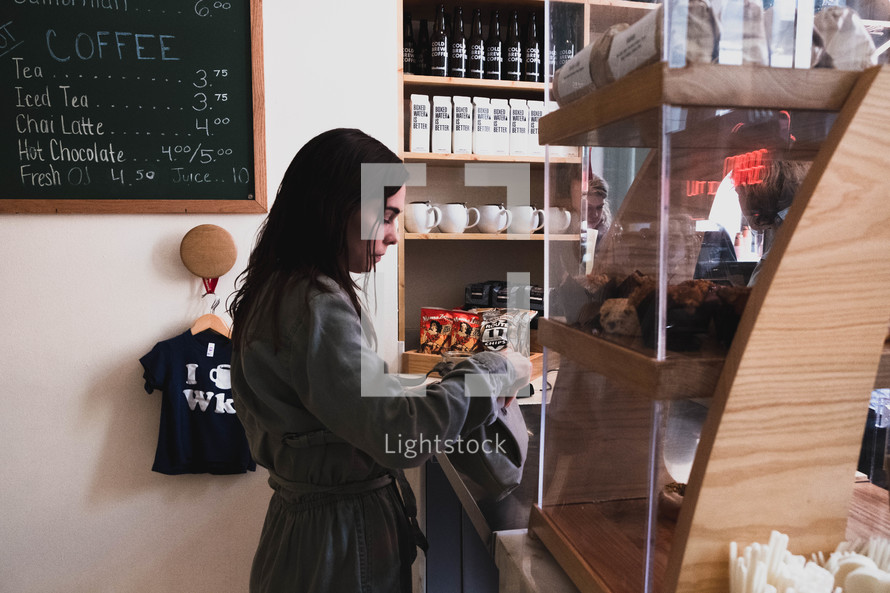 woman paying at a coffee shop 